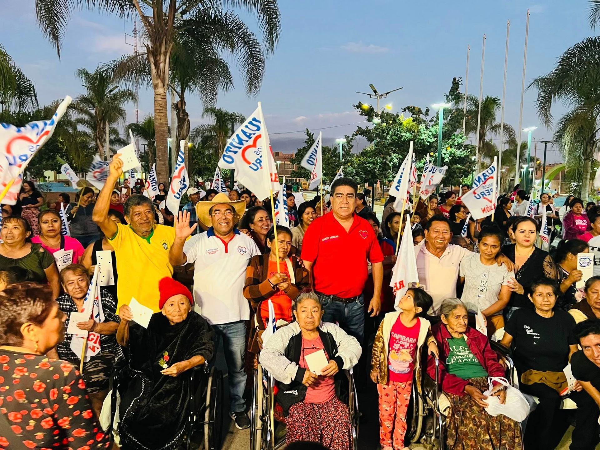 Multitud con banderas de Somos Perú al atardecer